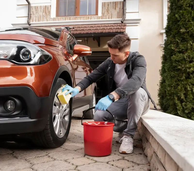 Lavage auto à domicile Saint-Genis-Pouilly : professionnel intervenant sur un véhicule